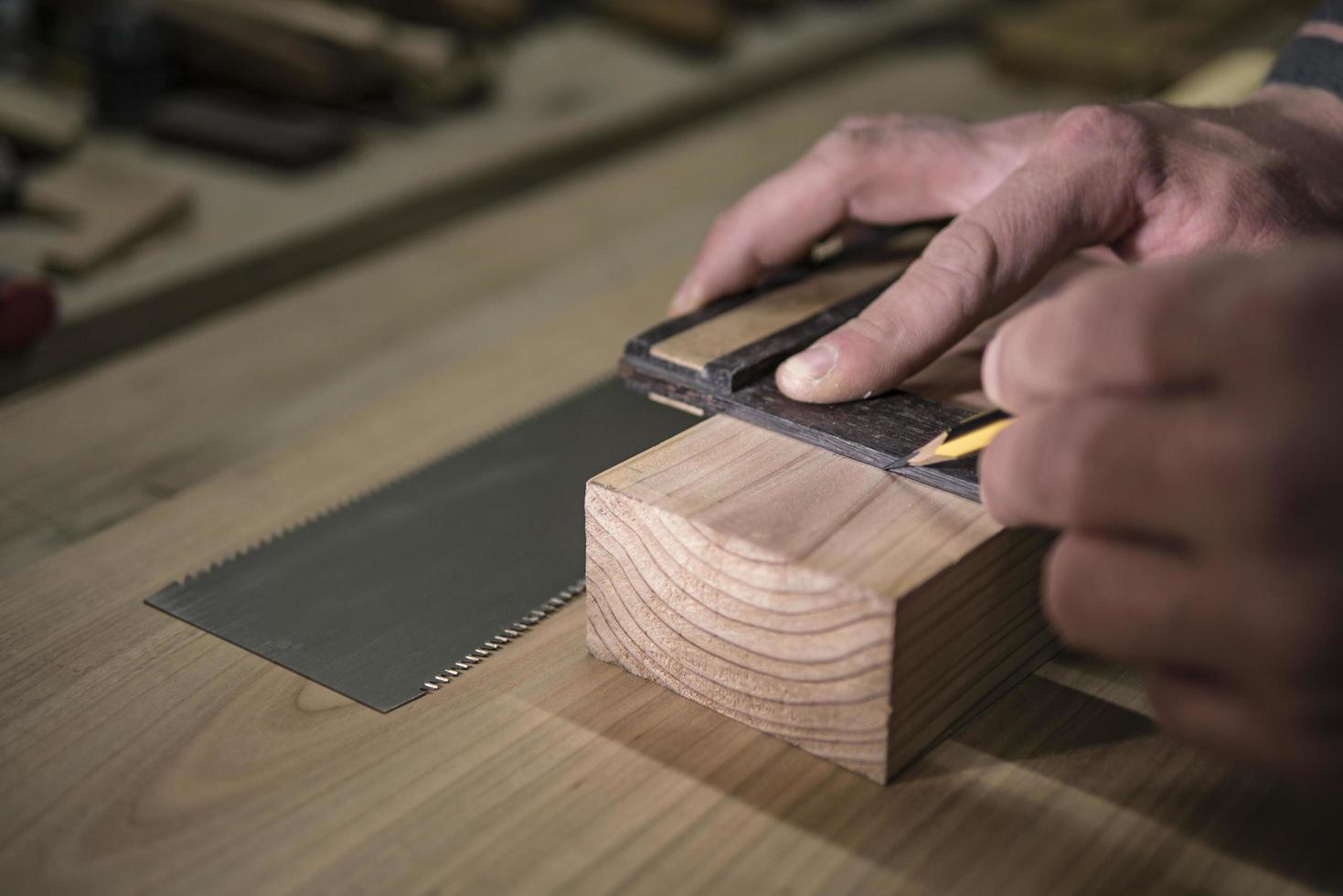 a joiner with a pencil and a square marks the workpiece photo