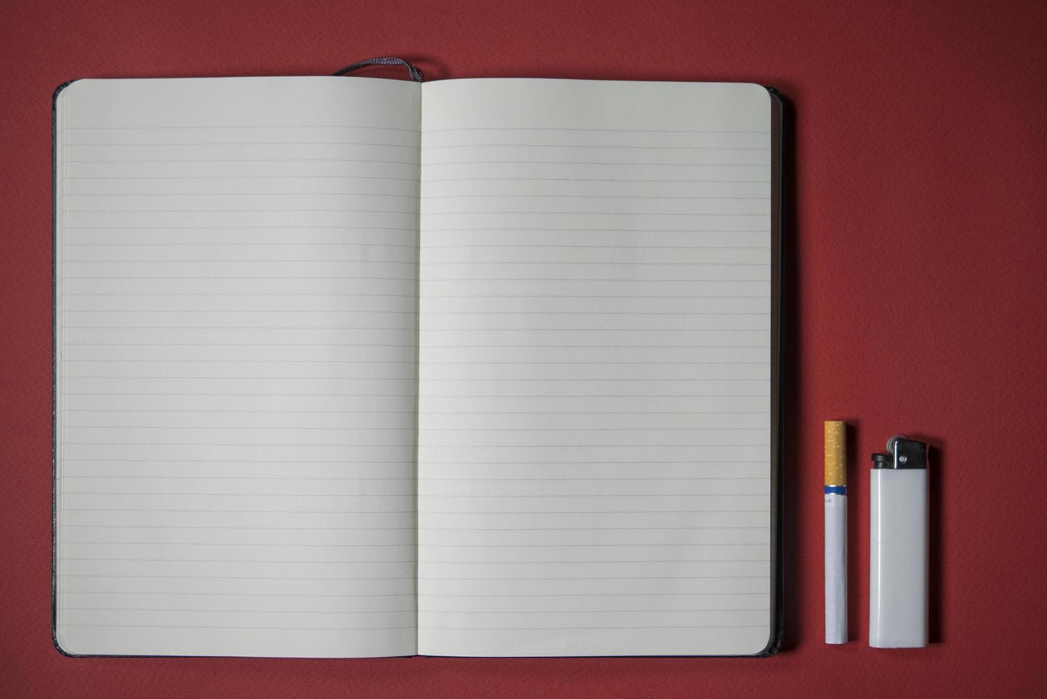 cigarette lighter and notebook writing on a red background photo