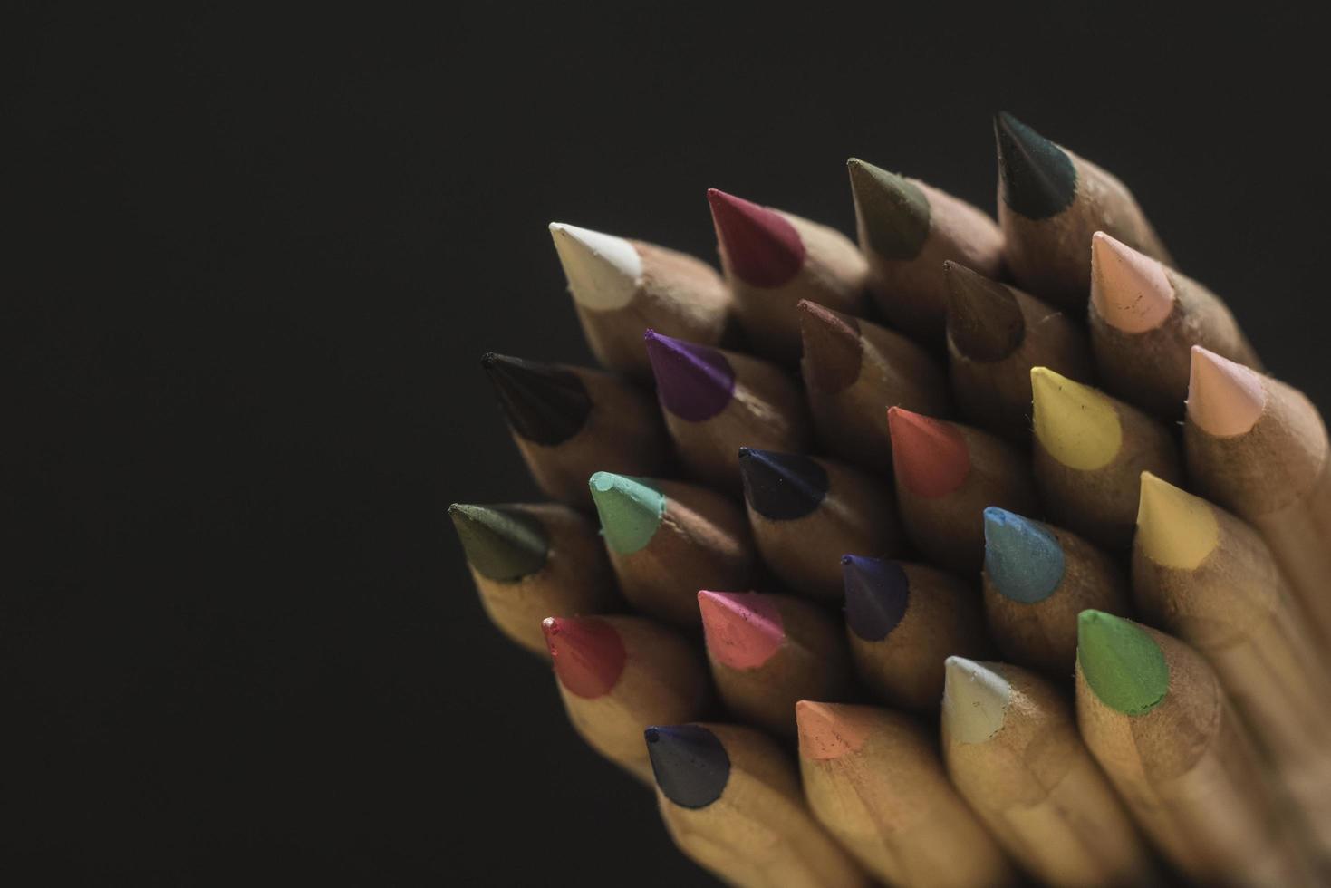 sharp colored pencils on a black background copy space photo