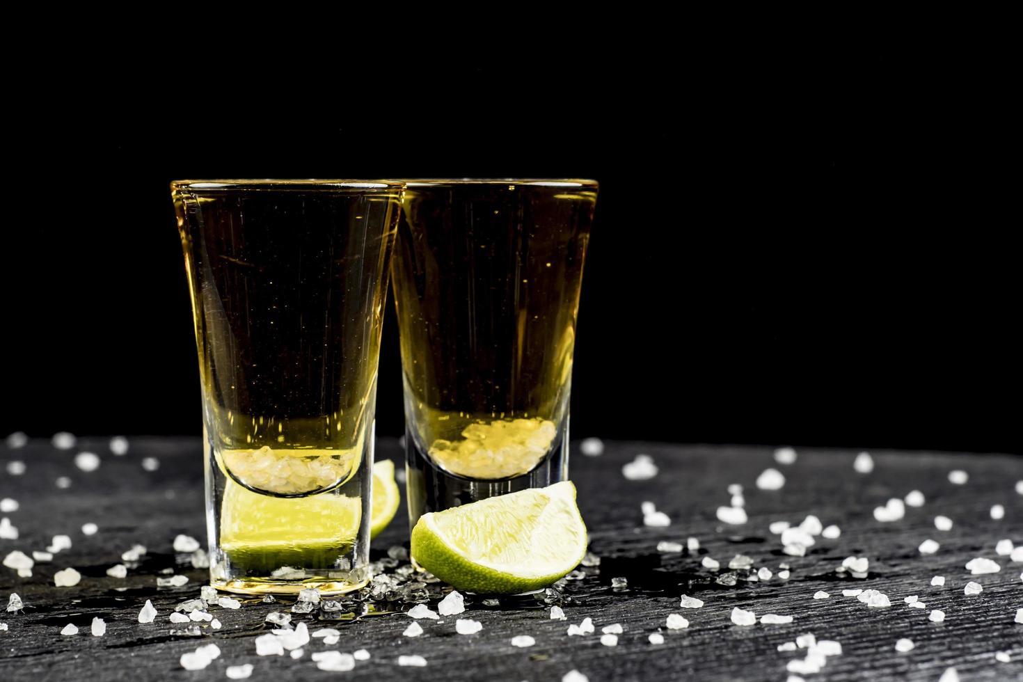 two glasses of tequila with lime and salt photo