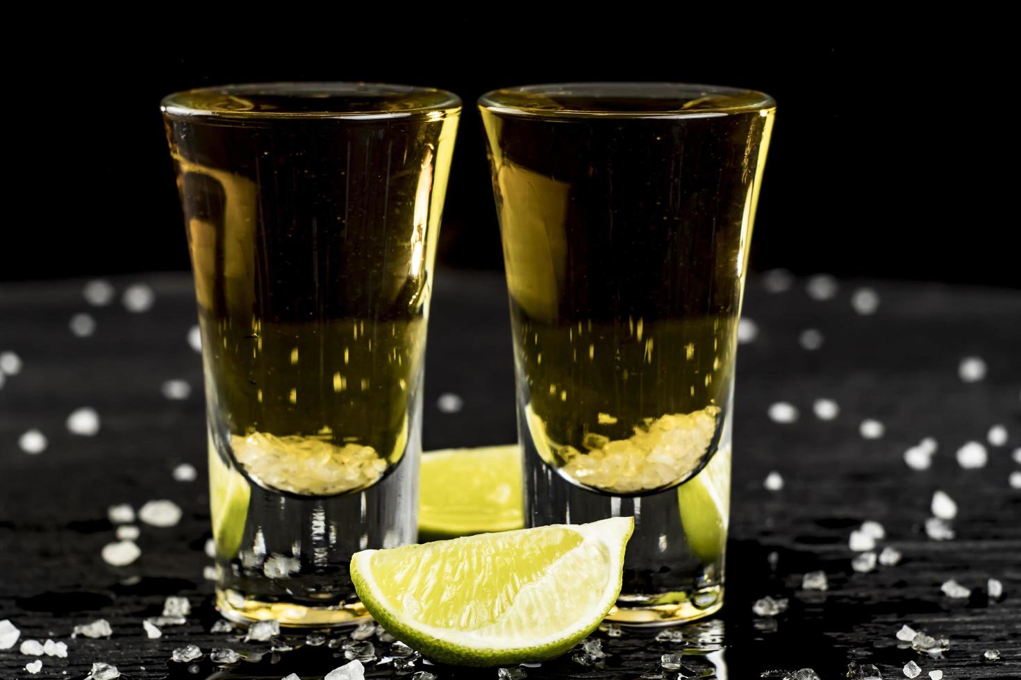 two glasses of tequila with lime and salt photo