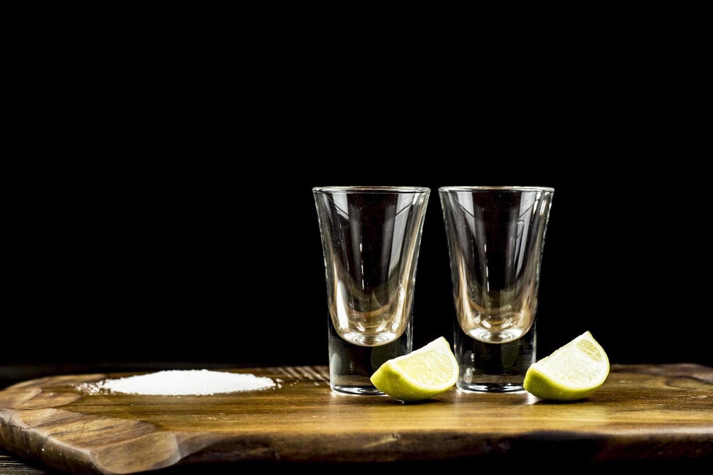 two glasses of tequila with lime and salt photo