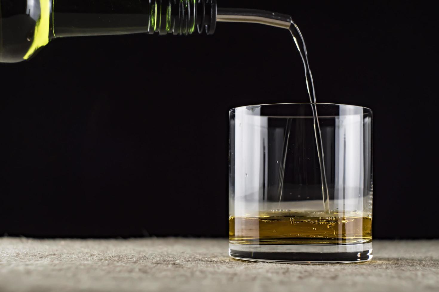 whiskey is poured into a glass photo