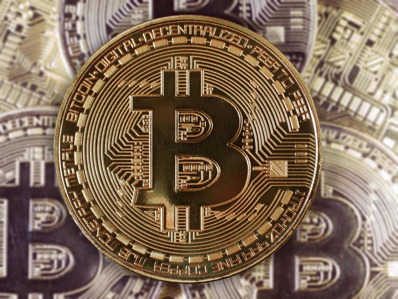 símbolo de bitcoin entre montones de bitcoins dorados foto