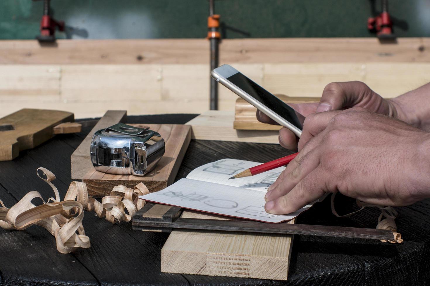 carpenter in the workshop with a red pencil looking at the blueprints photo