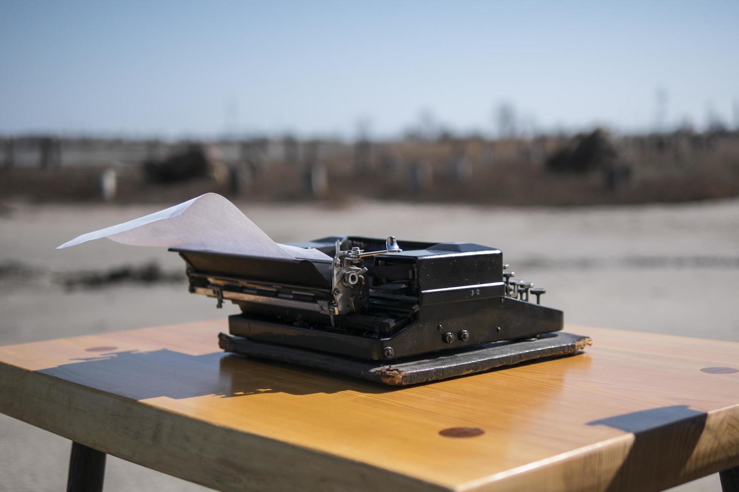Máquina de escribir sobre la mesa en el estuario al aire libre en el fondo foto