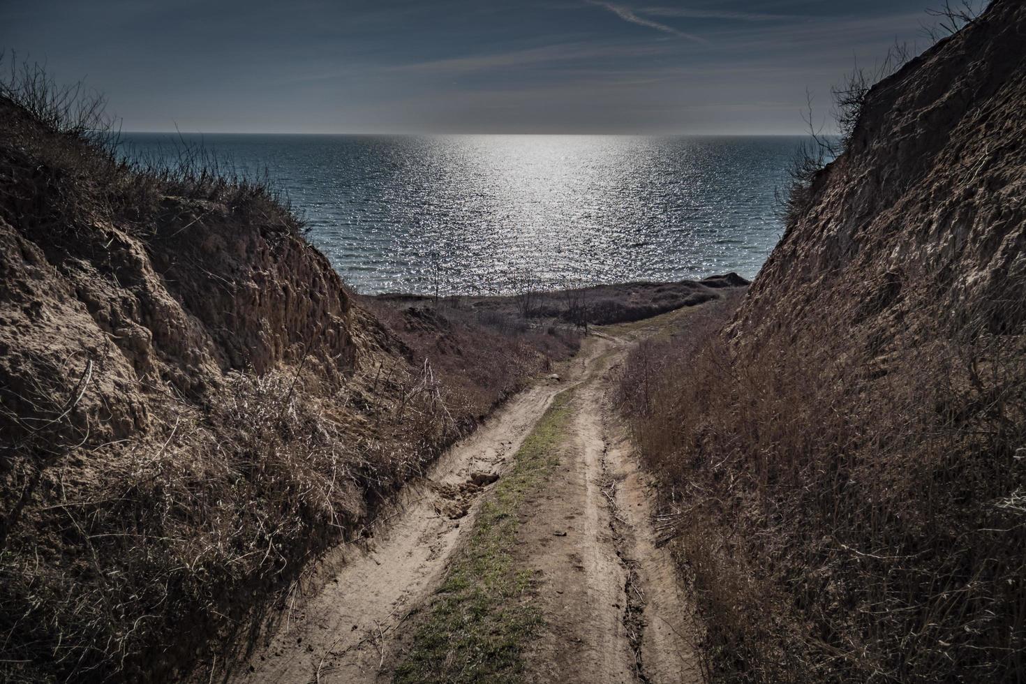 road to the sea between the rocks on a sunny day photo