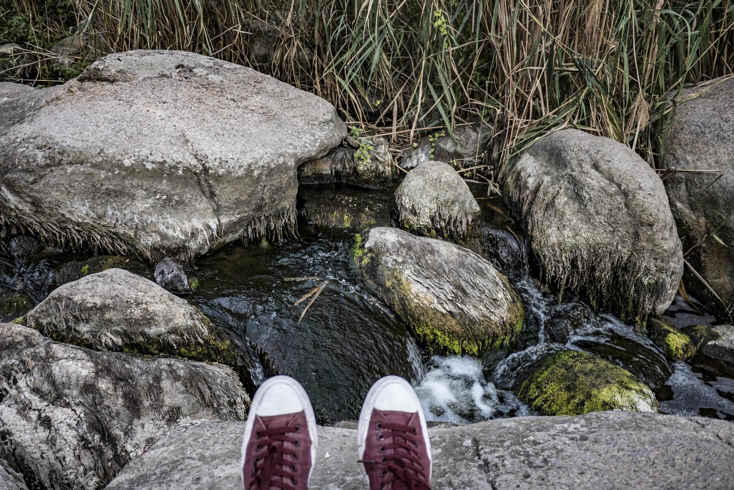 hiker in red sneakers by the waterfall photo