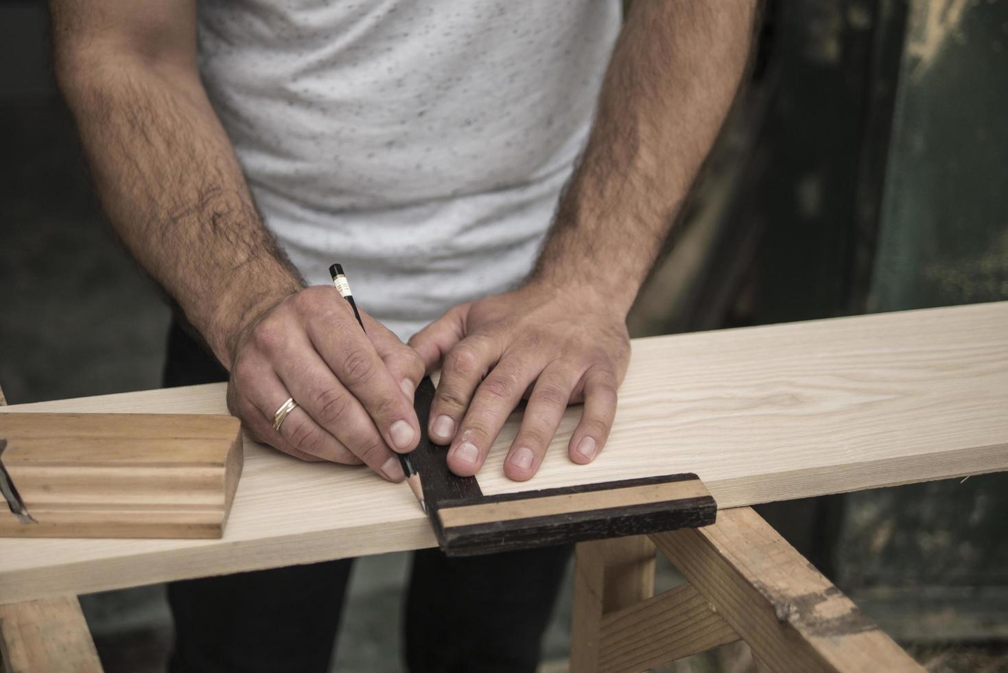 The joiner marks the workpiece with a pencil photo