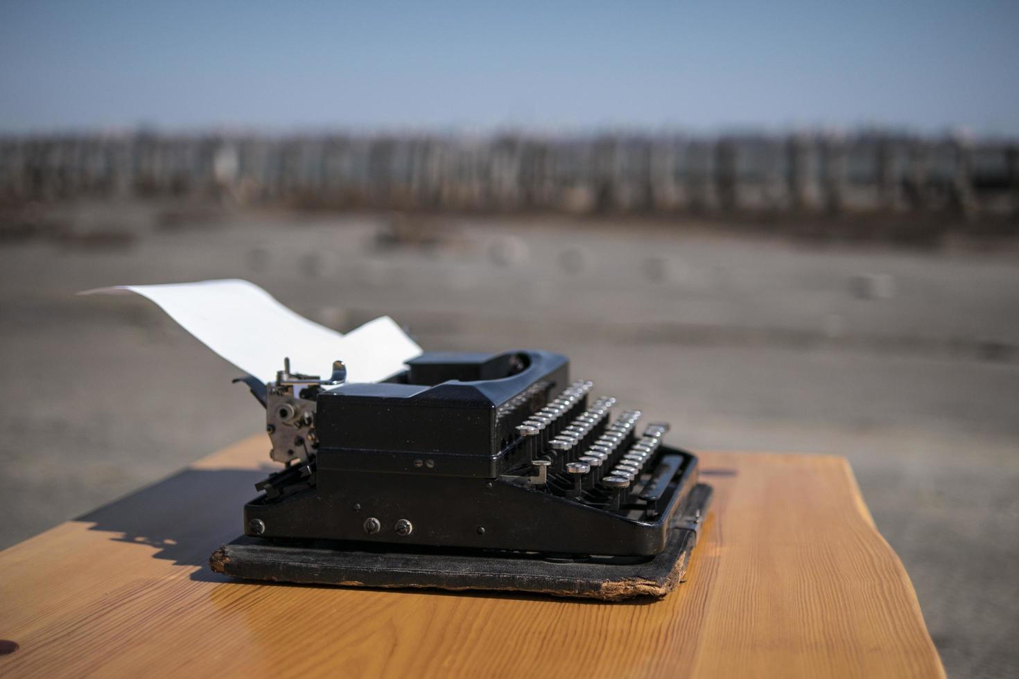 Máquina de escribir sobre la mesa en el estuario al aire libre en el fondo foto