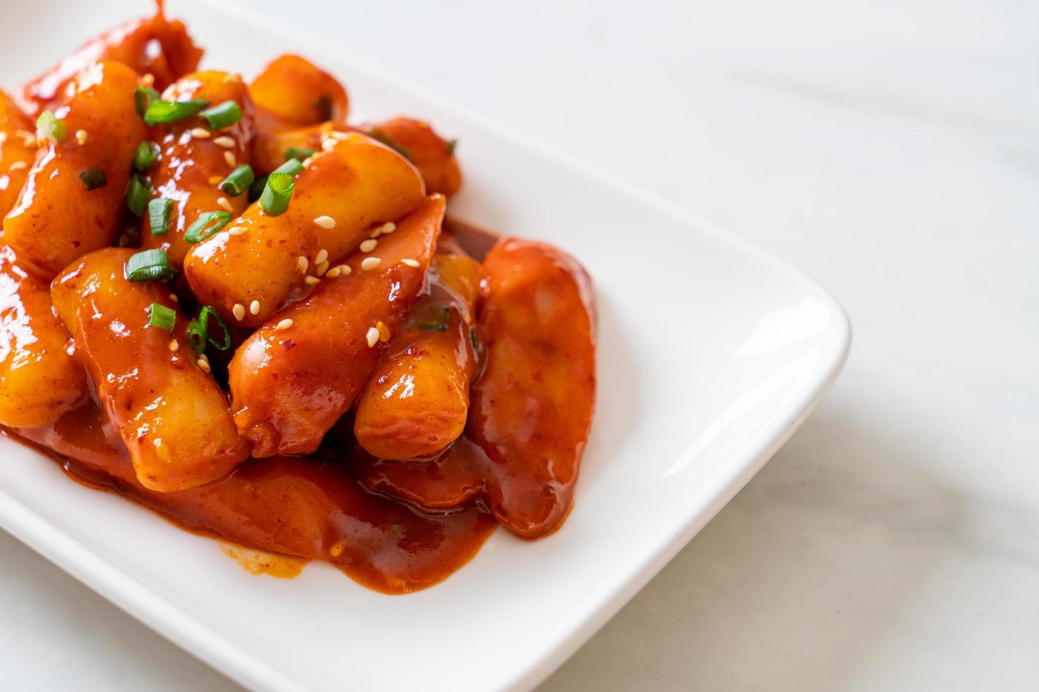 Korean rice cake stick with sausage in spicy sauce or Tteokbokki photo