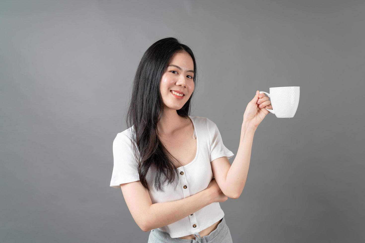 Young Asian woman with happy face and hand holding coffee cup photo