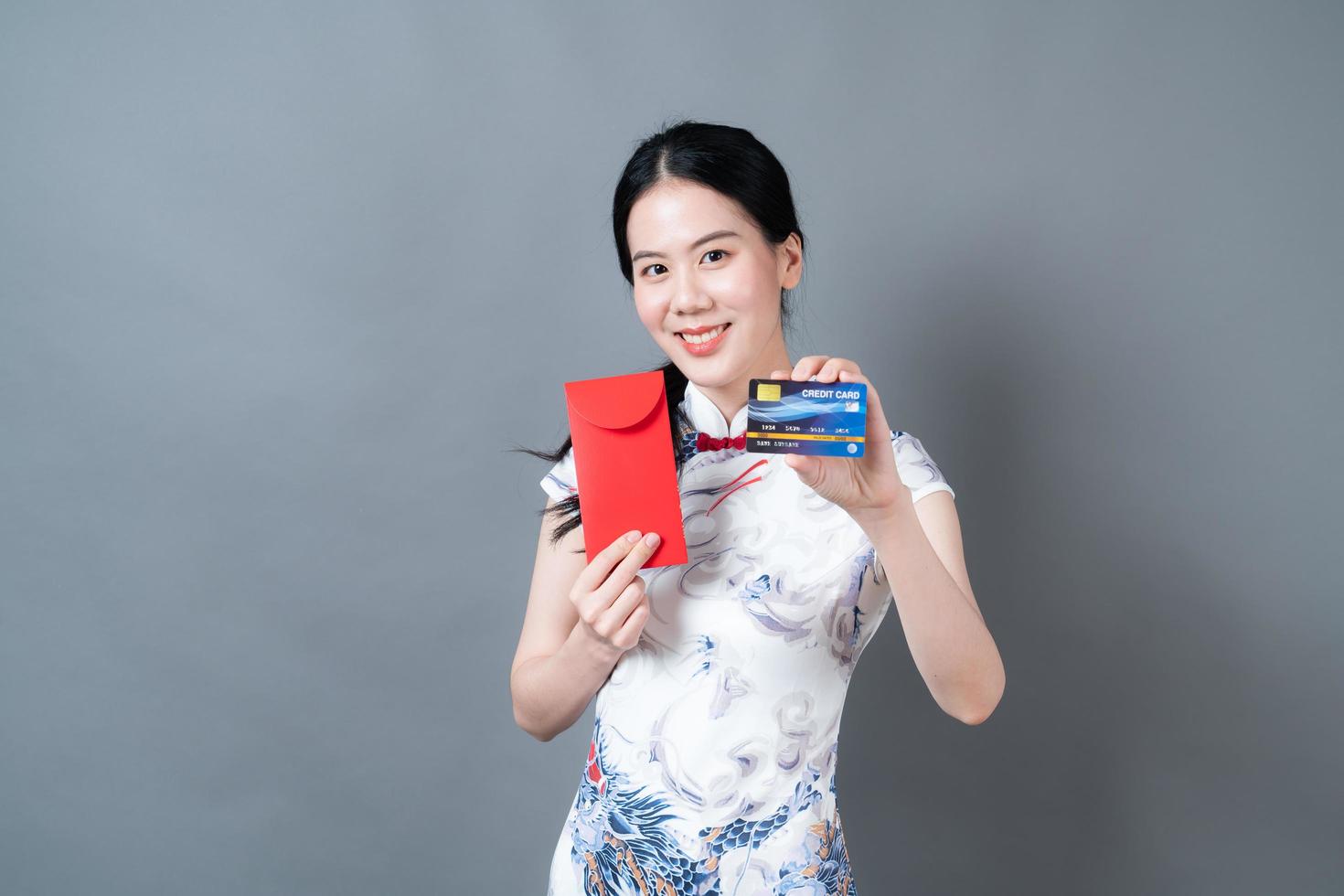 Asian woman wear Chinese traditional dress with red envelope or red packet and credit card photo