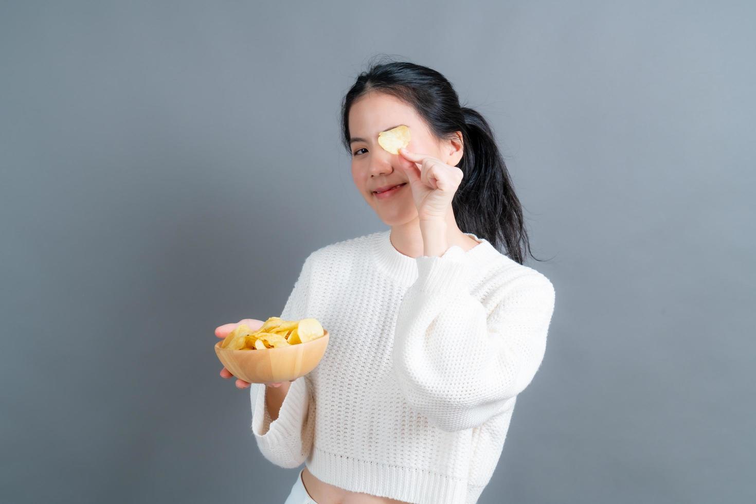 Young Asian woman eat potato chips photo