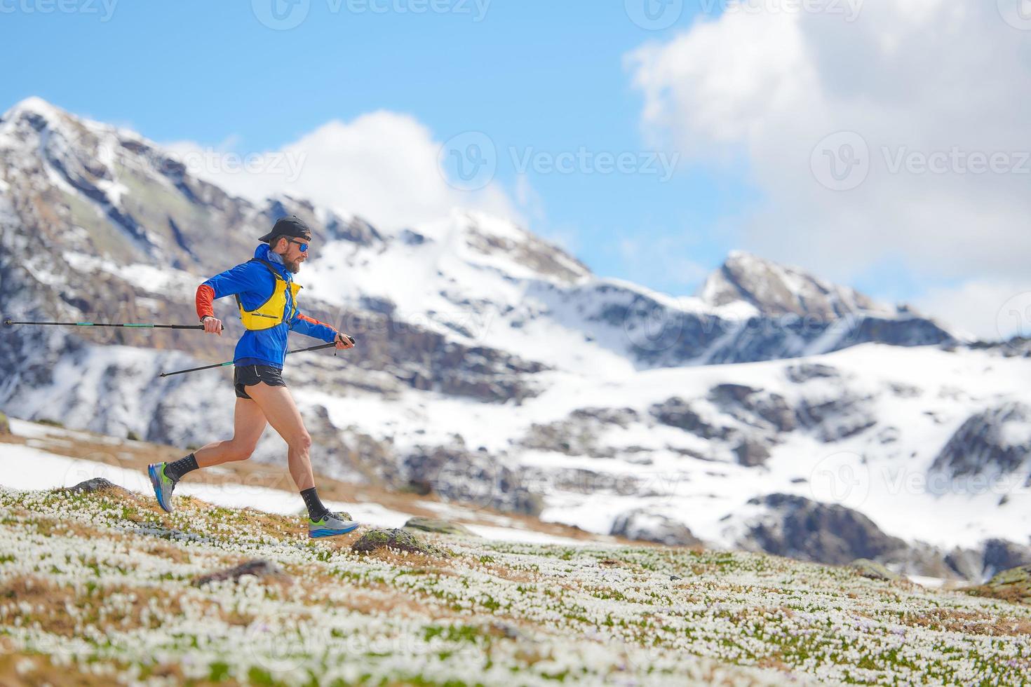 corredor de montaña con palillos en el entrenamiento cuesta abajo foto