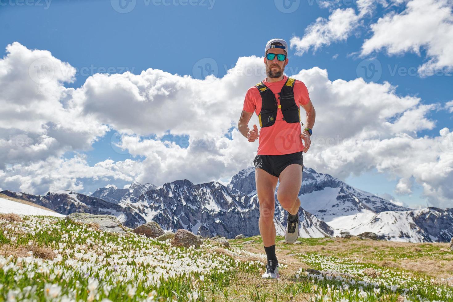 Fuerte atleta de trail running en las montañas en formación foto