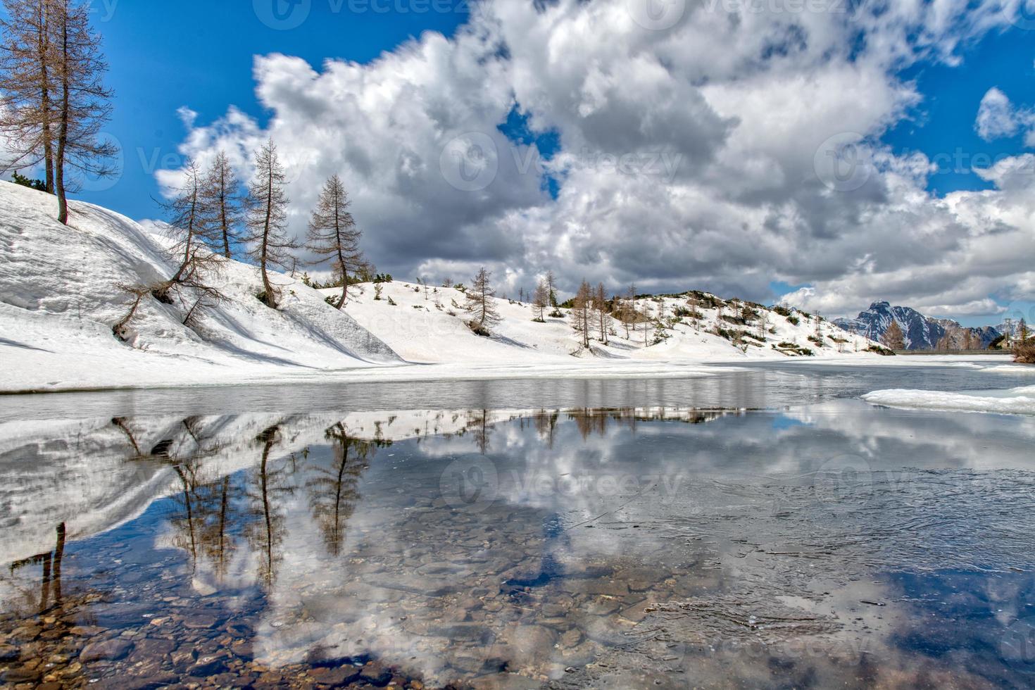 primavera y deshielo cerca del lago alpino en las montañas foto