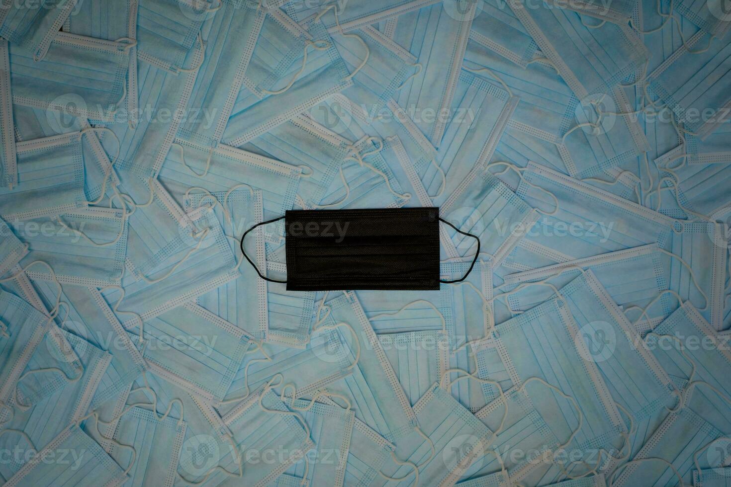 Black surgical face mask on blue masks background photo