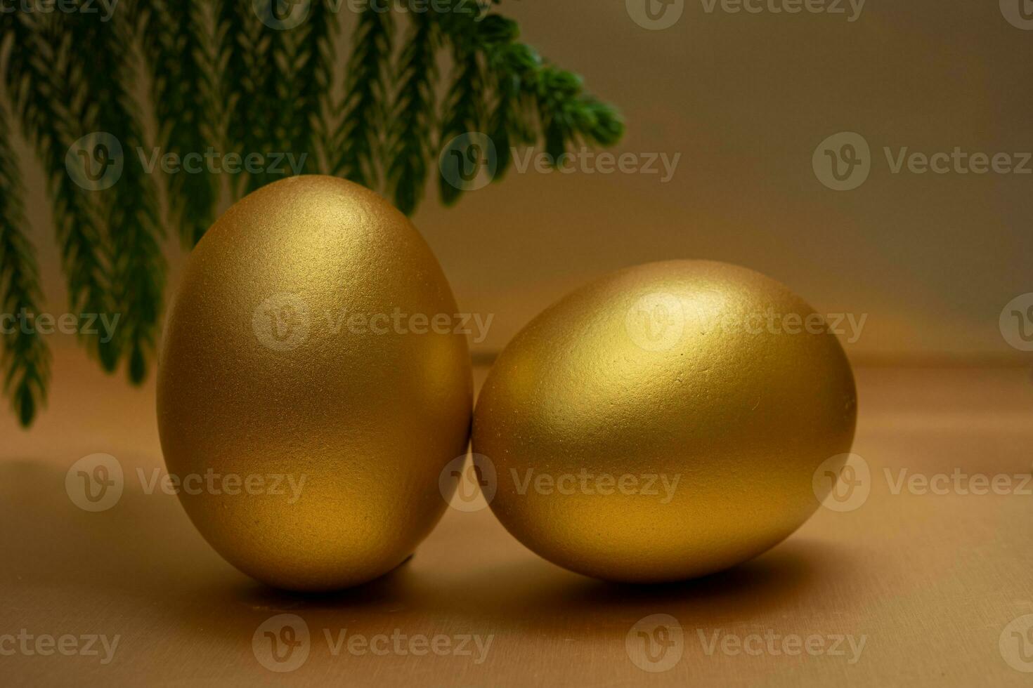 2 huevos de oro sobre fondo dorado foto