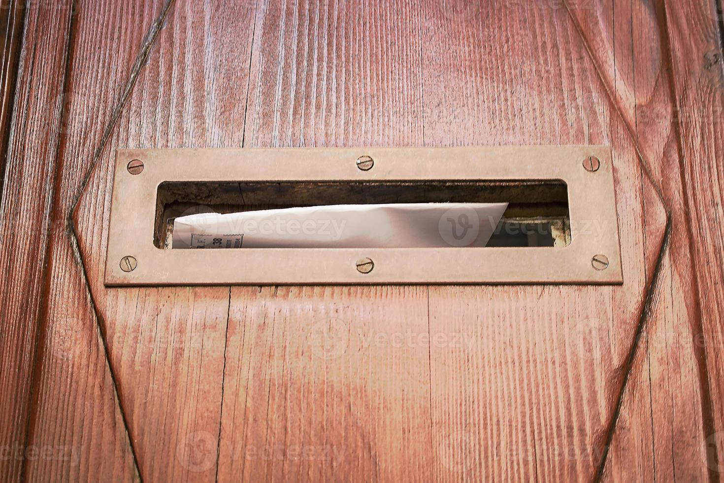 Mail box hole in wooden door with letter photo