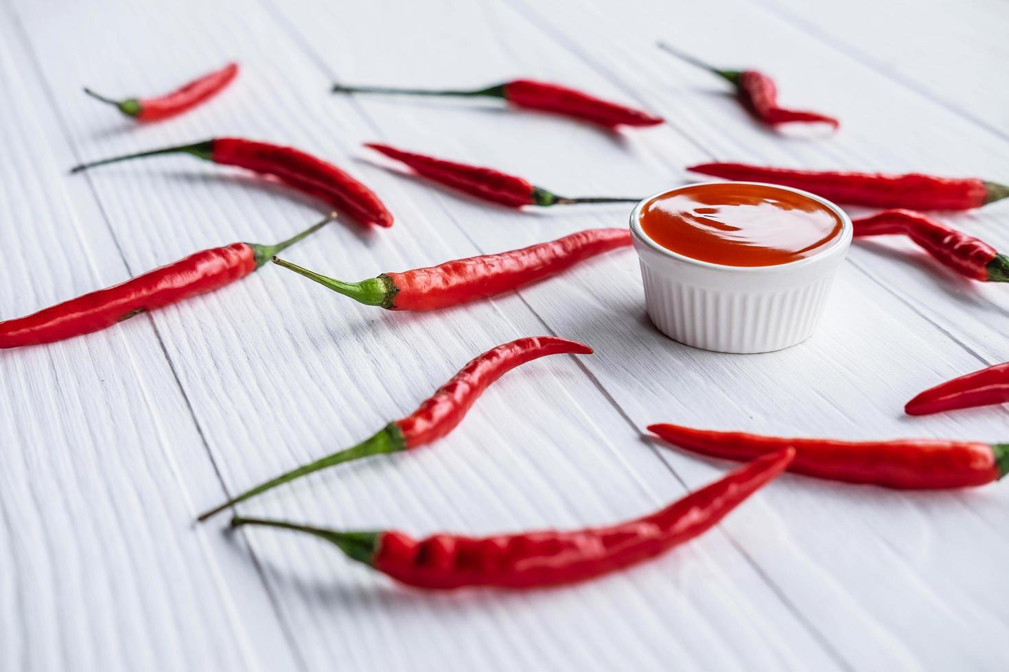 Fresh chillies with hot chili sauce on the table photo