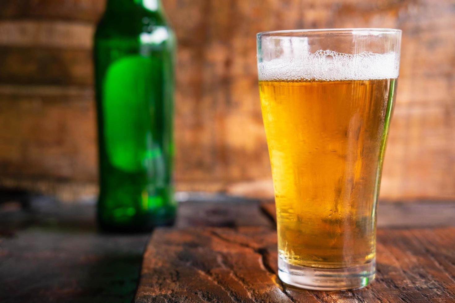 Beer mugs and beer bottles on a wooden table photo