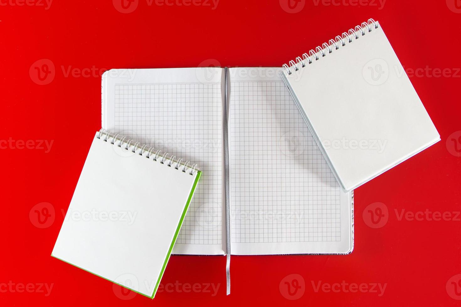 suministros de oficina cuadernos sobre fondo rojo foto