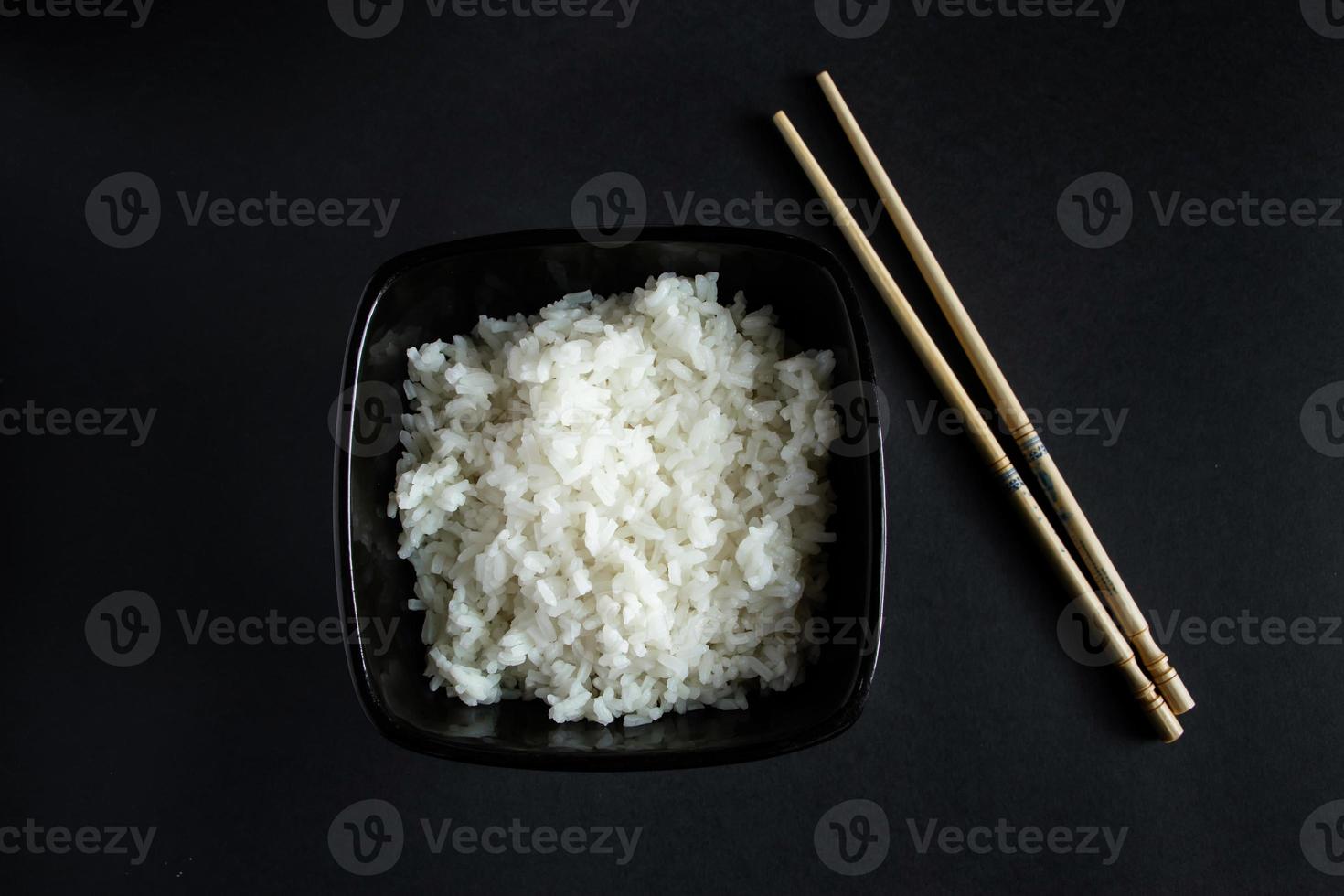 Cuenco con arroz hervido sobre fondo negro foto