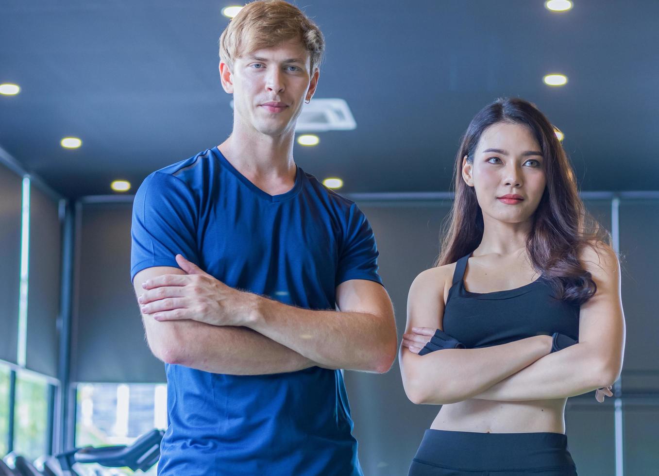 Par de jóvenes sonríen relajarse después de entrenar en el gimnasio conceptos de ejercicio saludable foto