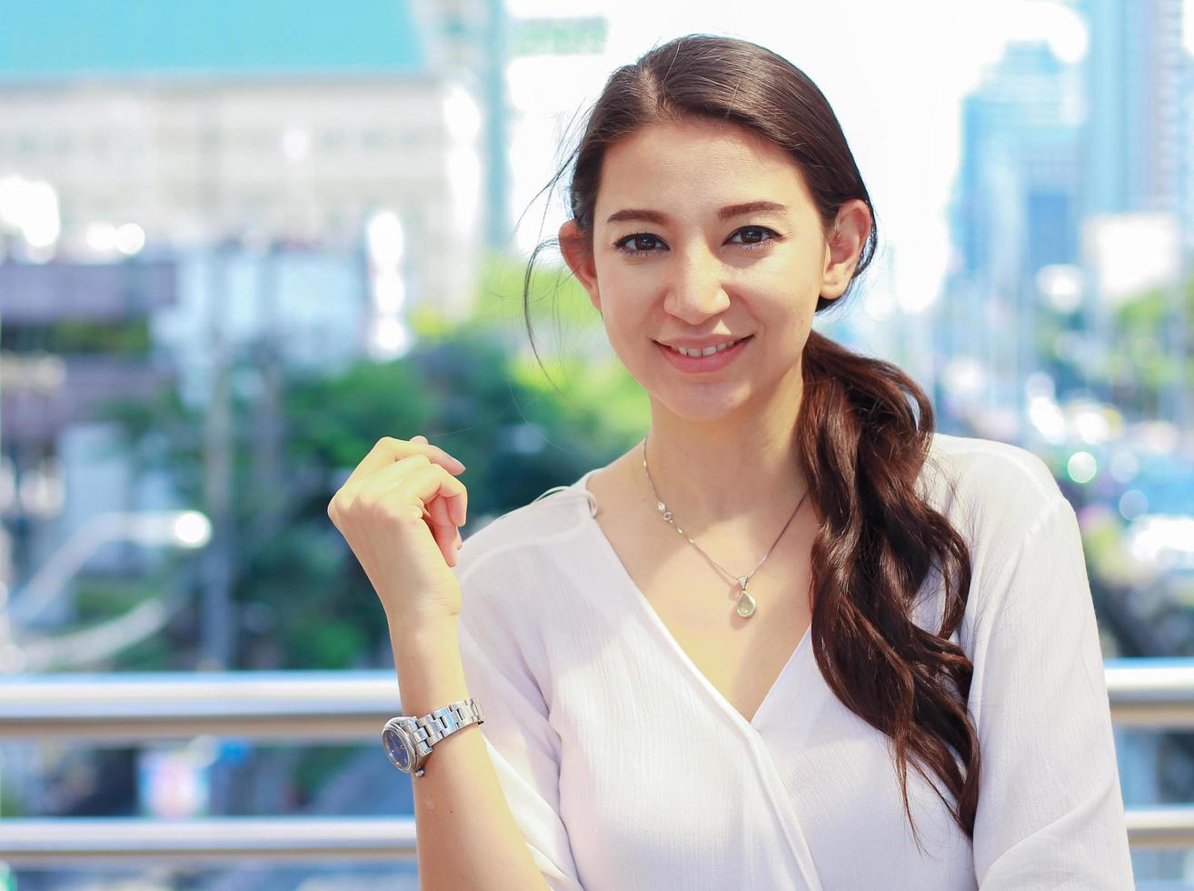 Portrait of a beautiful woman standing in a city building smiling happily Urban lifestyle photo