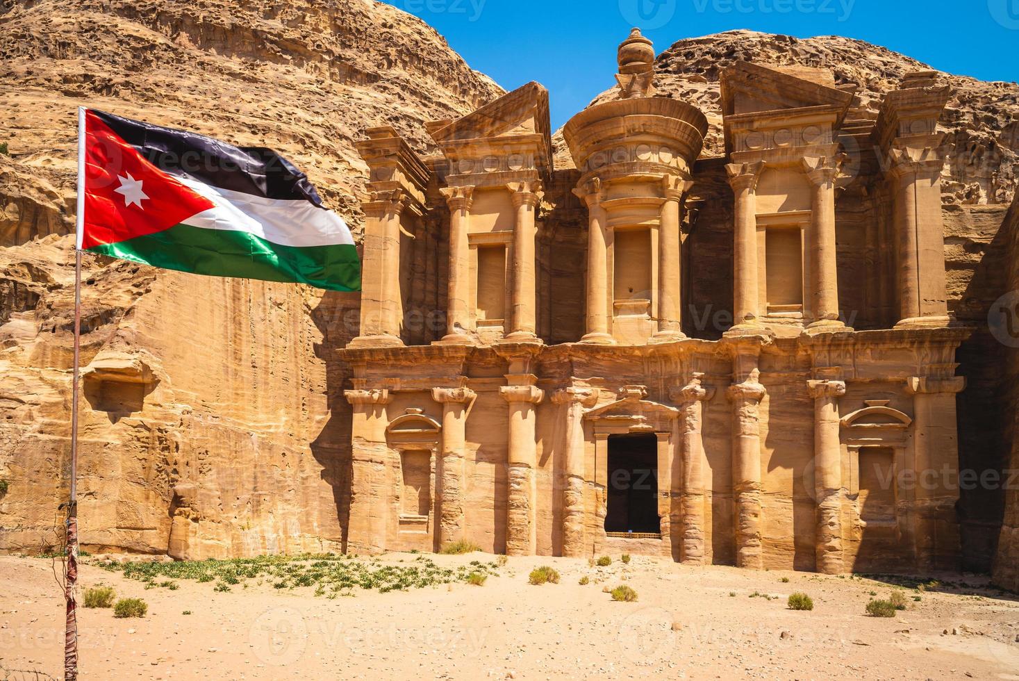 Jordan flag and Ad Deir aka The Monastery located at Petra in Jordan photo