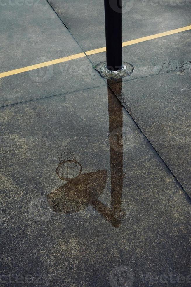 street basketball hoop reflected on the puddle photo