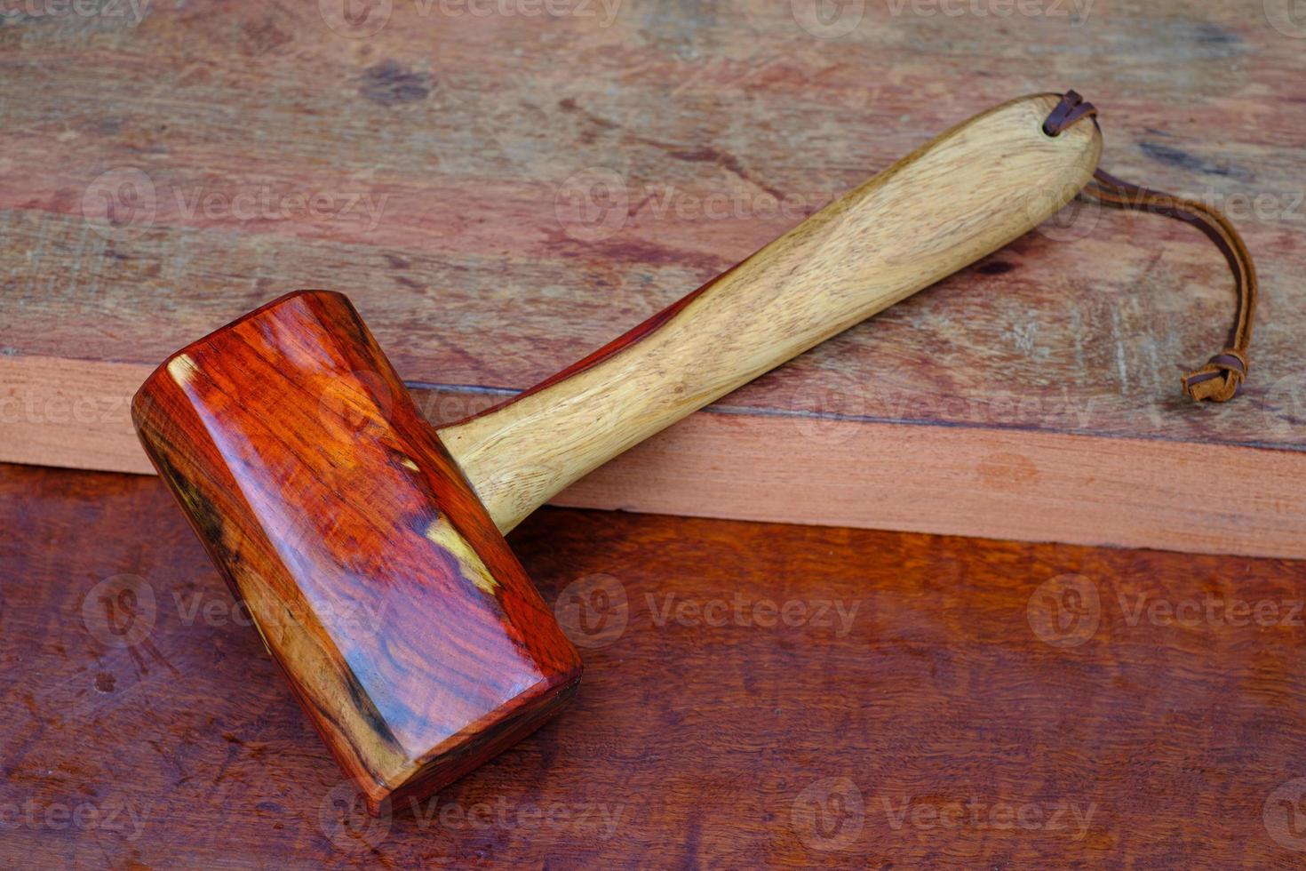 Martillo mazo de madera de palisandro y herramienta hecha a mano de Tailandia para su uso por un carpintero en el taller en el antiguo banco de trabajo foto