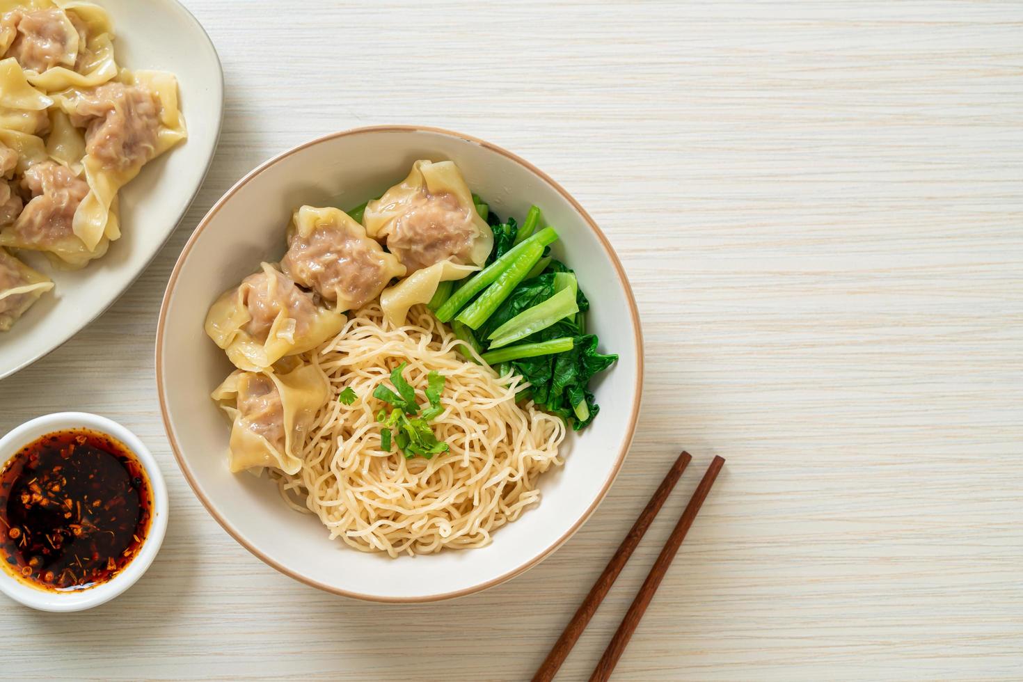 Dried egg noodles with pork wonton or pork dumplings without soup - Asian food style photo