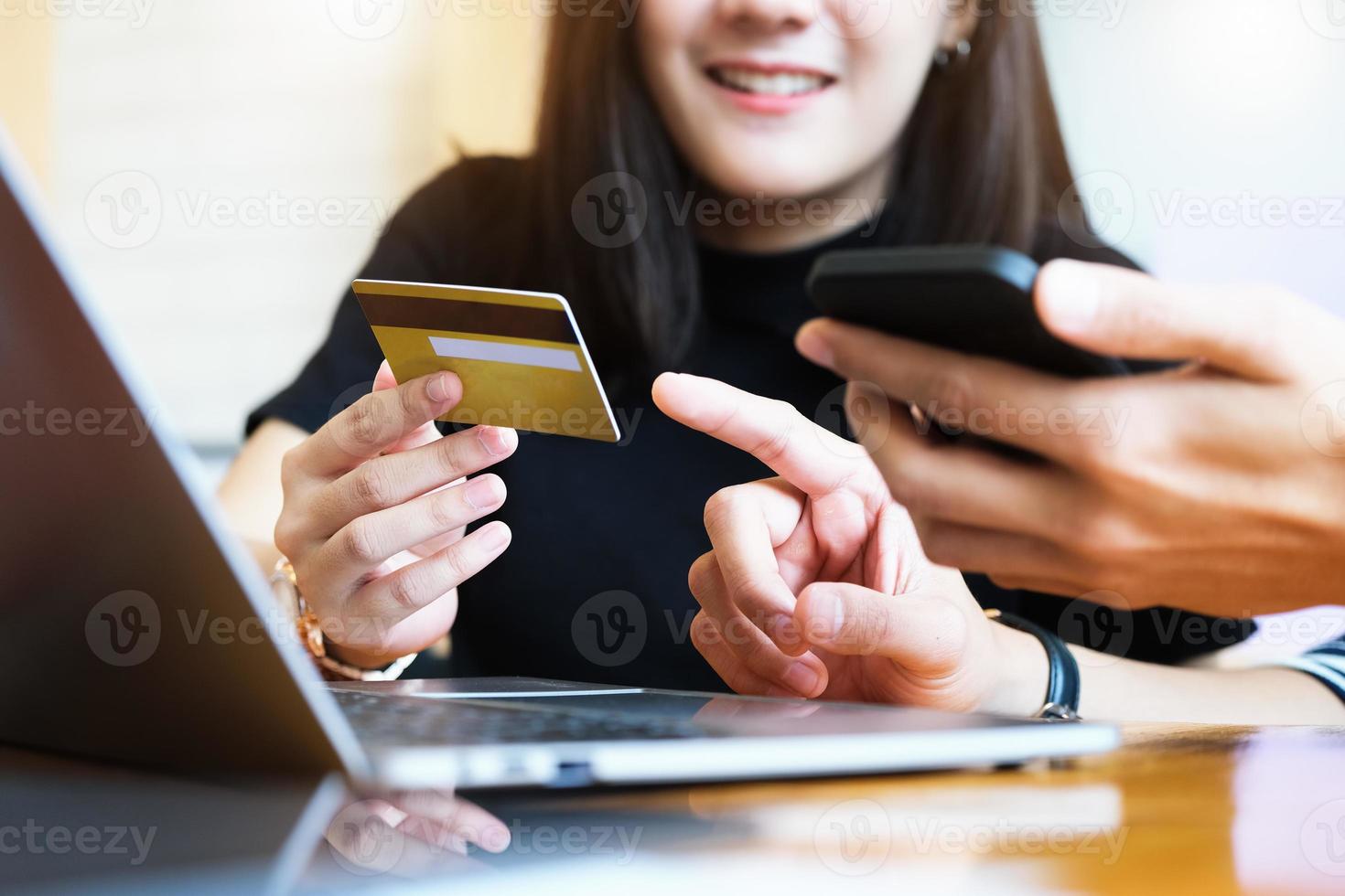 dos personas que usan teléfonos inteligentes y computadoras para compras en línea foto