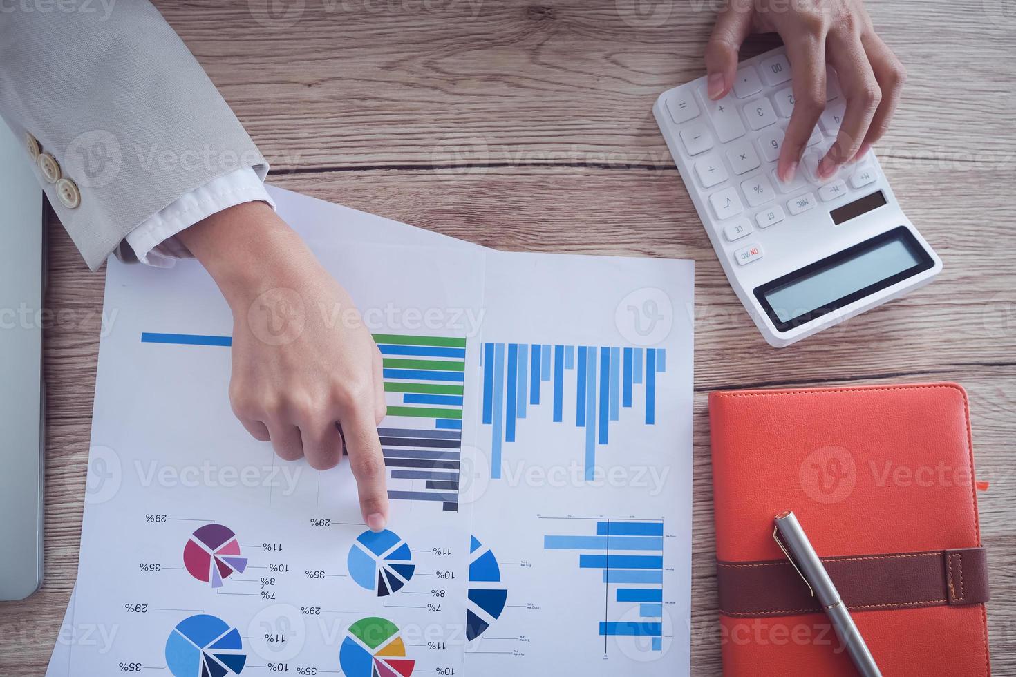 Businessman pointing to chart and using calculator to calculate budget photo