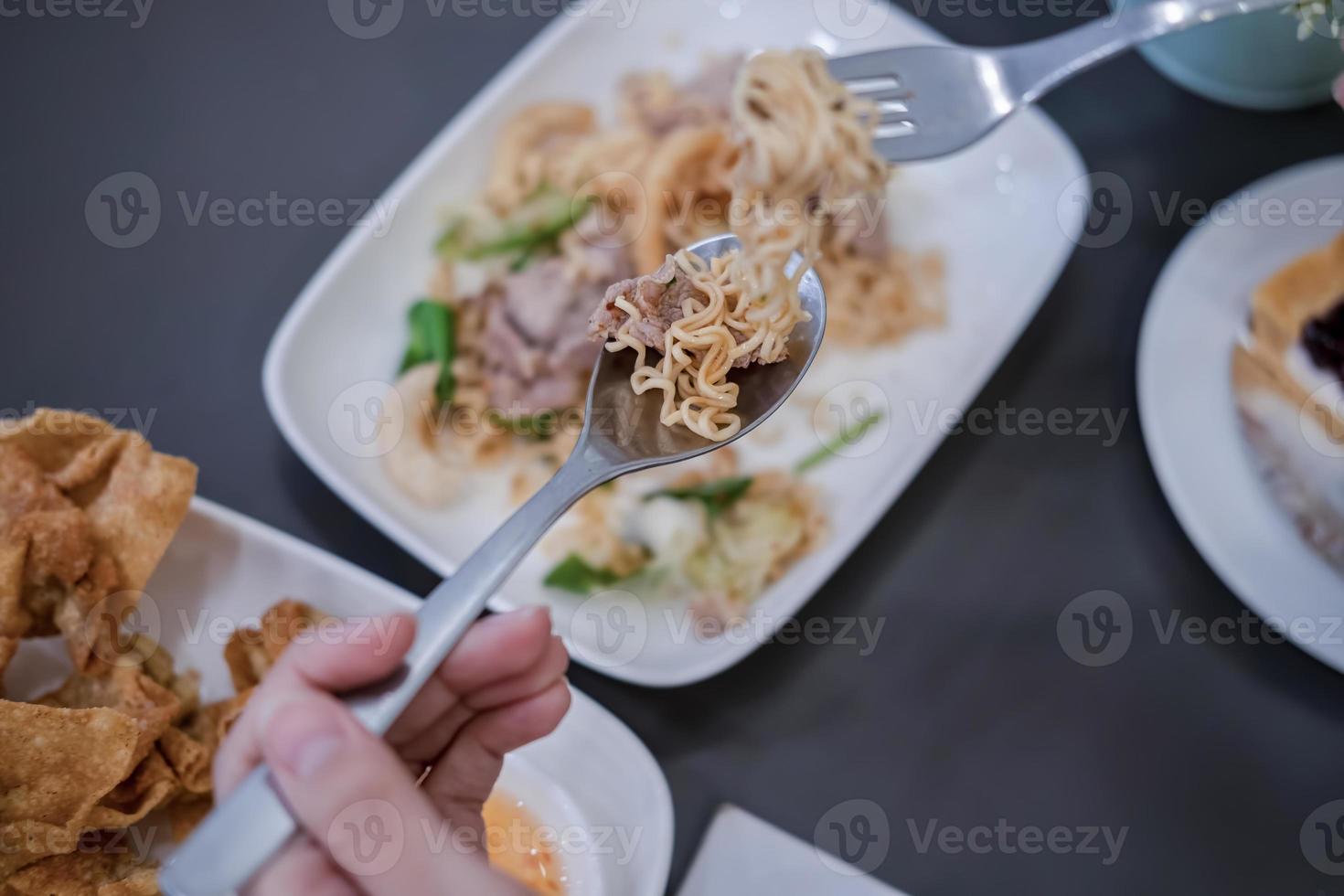 Woman eating delicious instant noodles photo