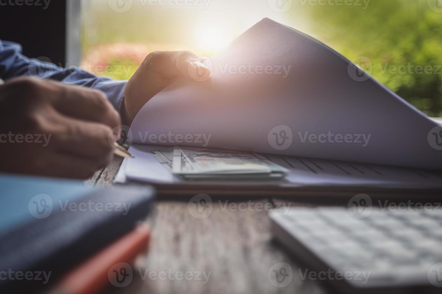 Businessman with contract document and dollars under the document photo