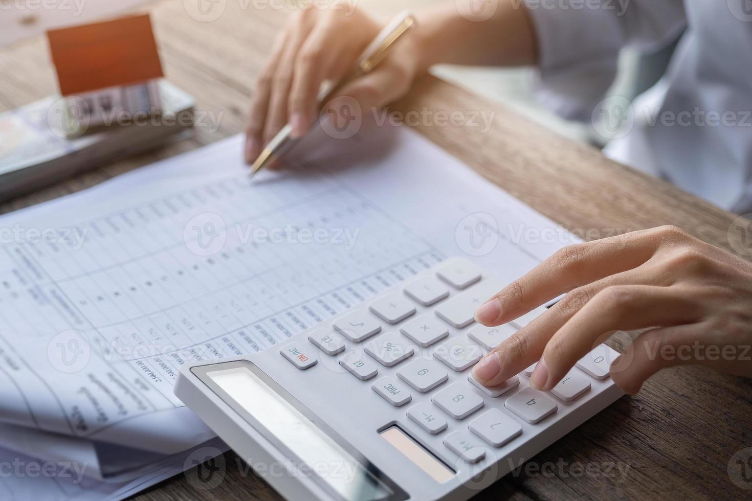 Customer uses pen and calculator photo