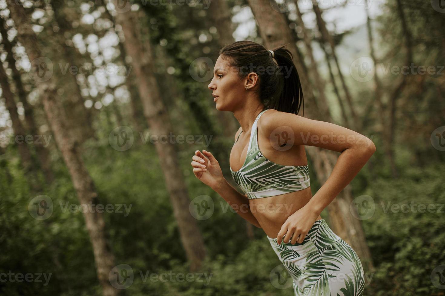 joven fitness mujer corriendo en pista forestal foto