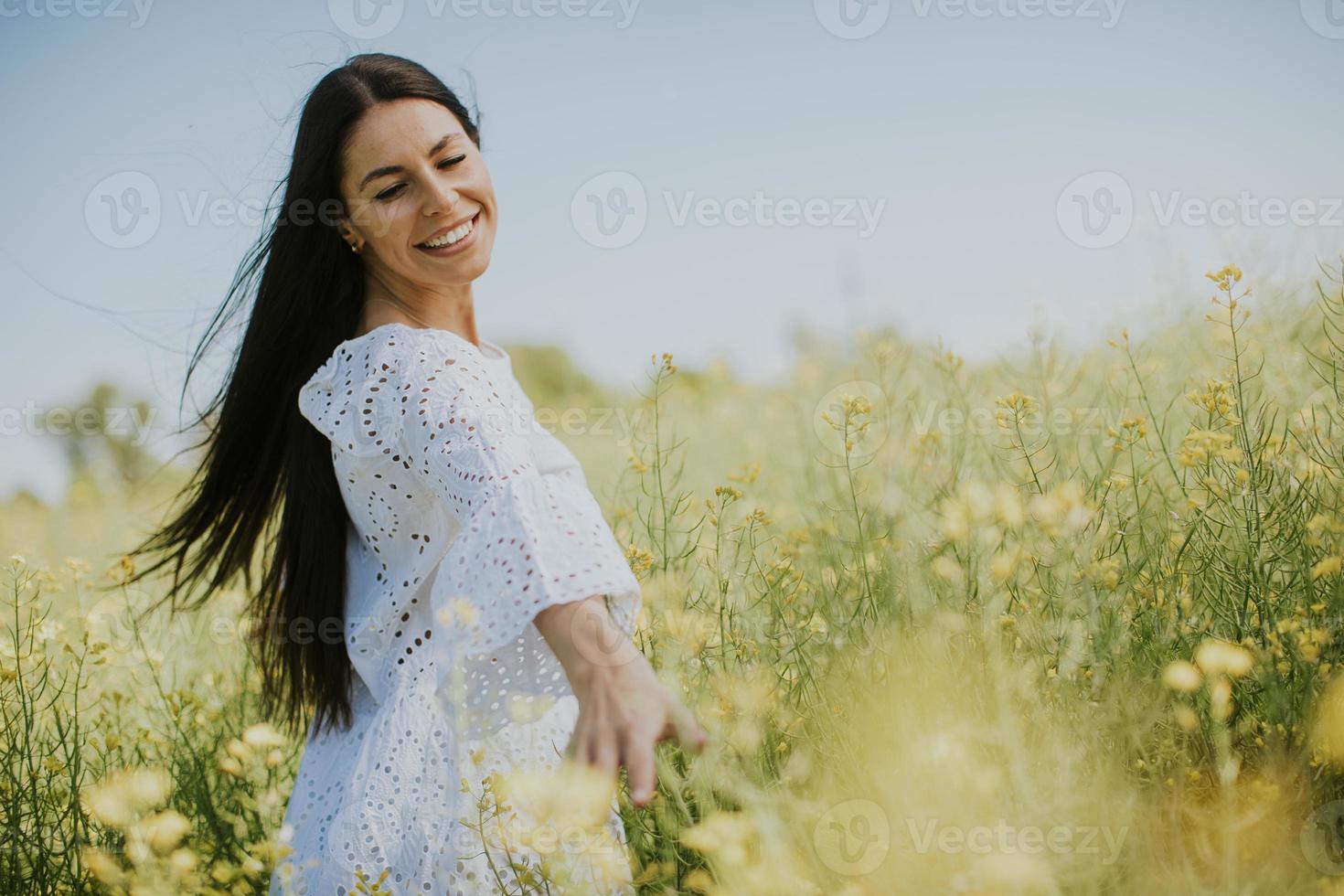 mujer joven en el campo de colza foto