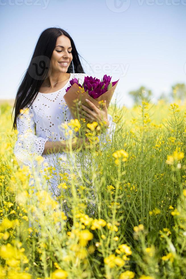 mujer joven en el campo de colza foto