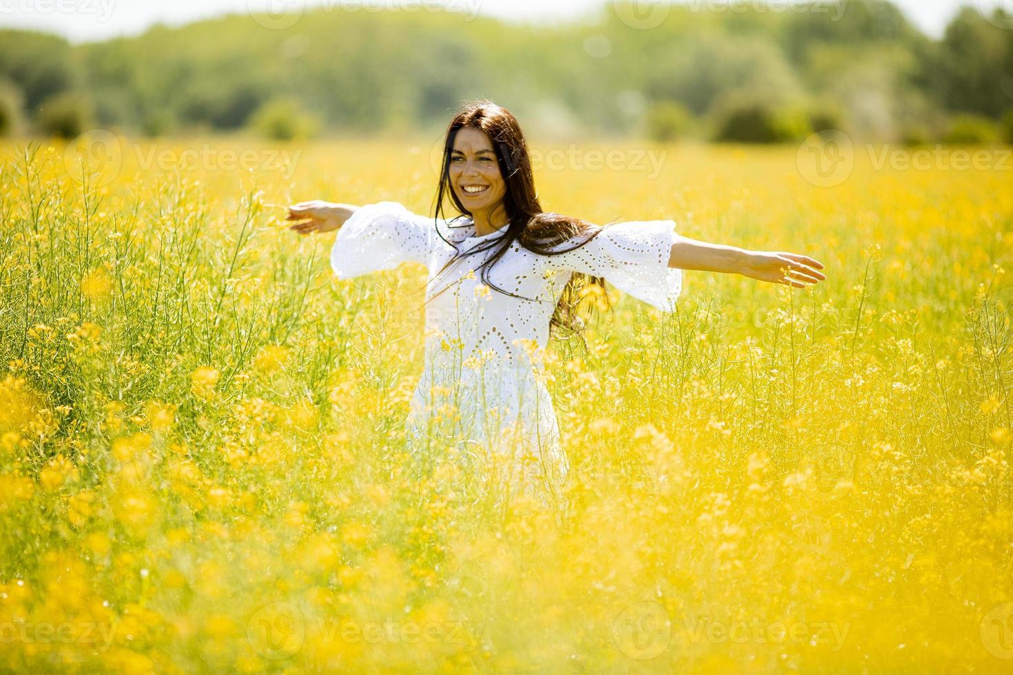 mujer joven en el campo de colza foto