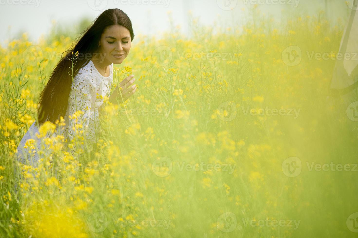 mujer joven en el campo de colza foto