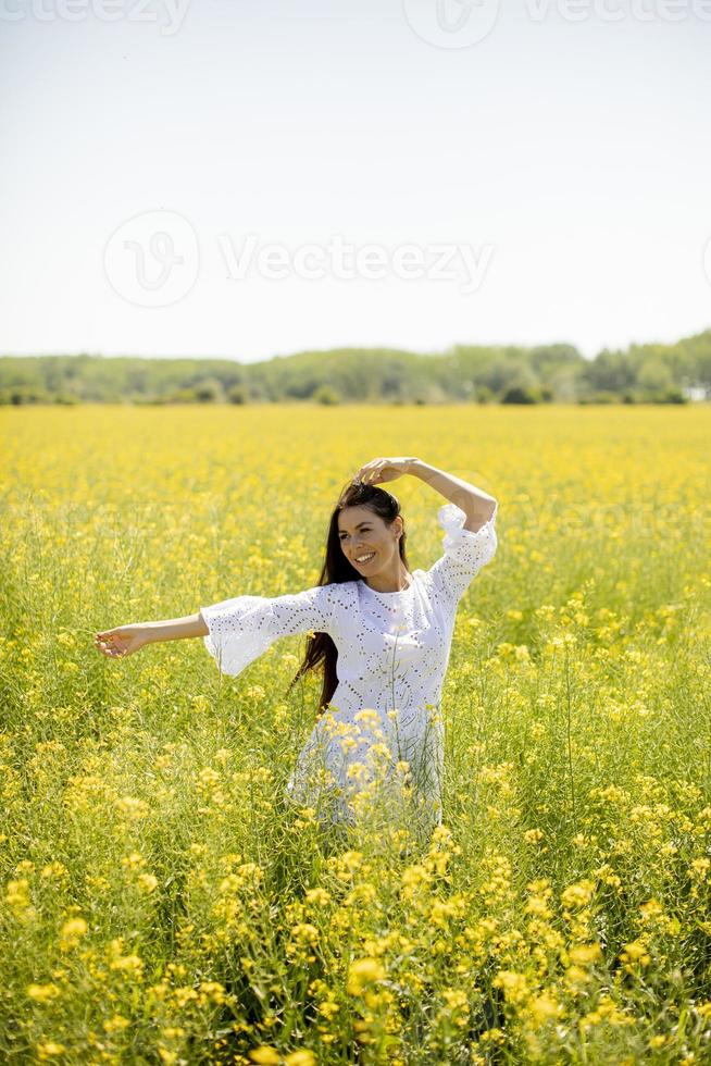 mujer joven en el campo de colza foto