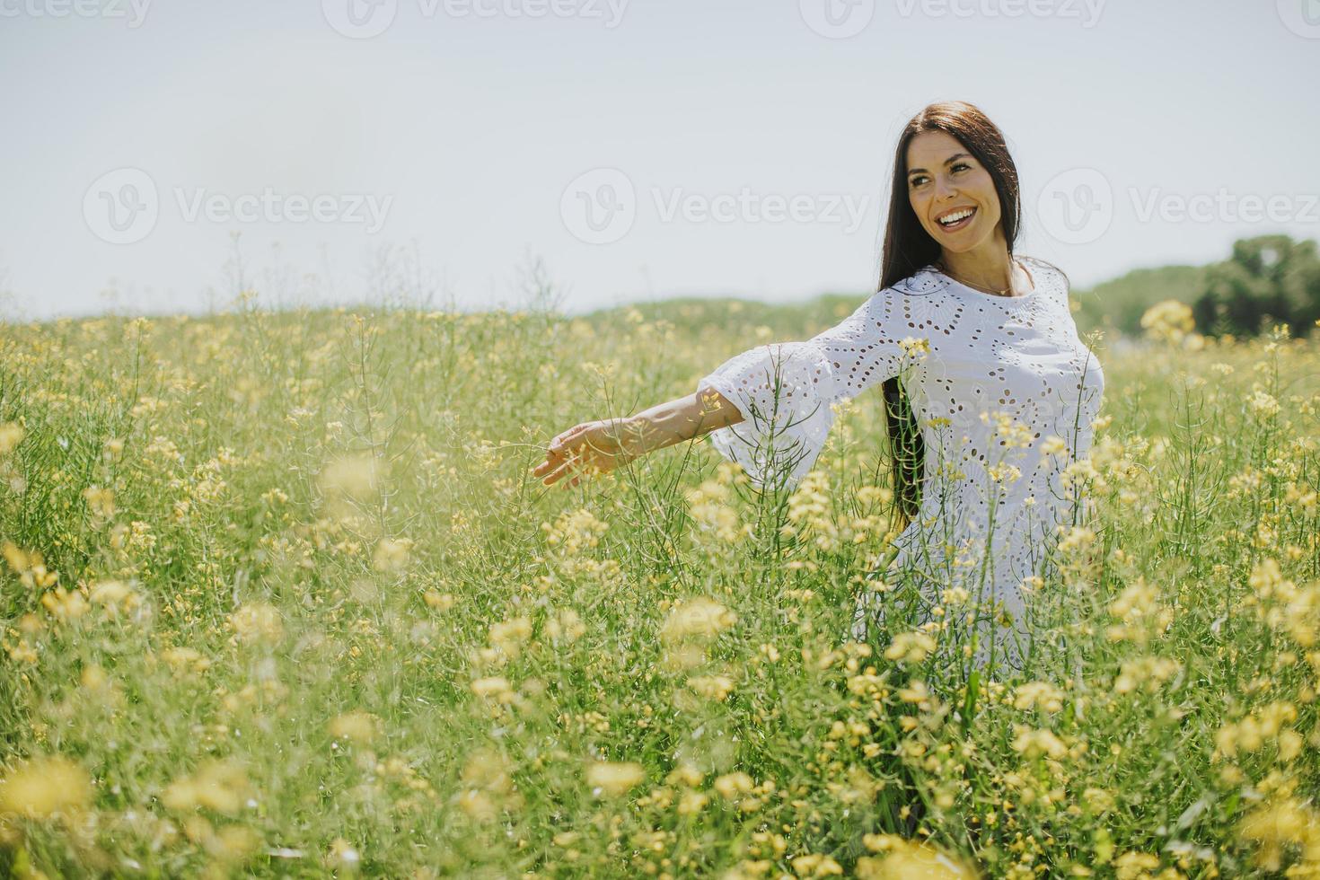 mujer joven en el campo de colza foto