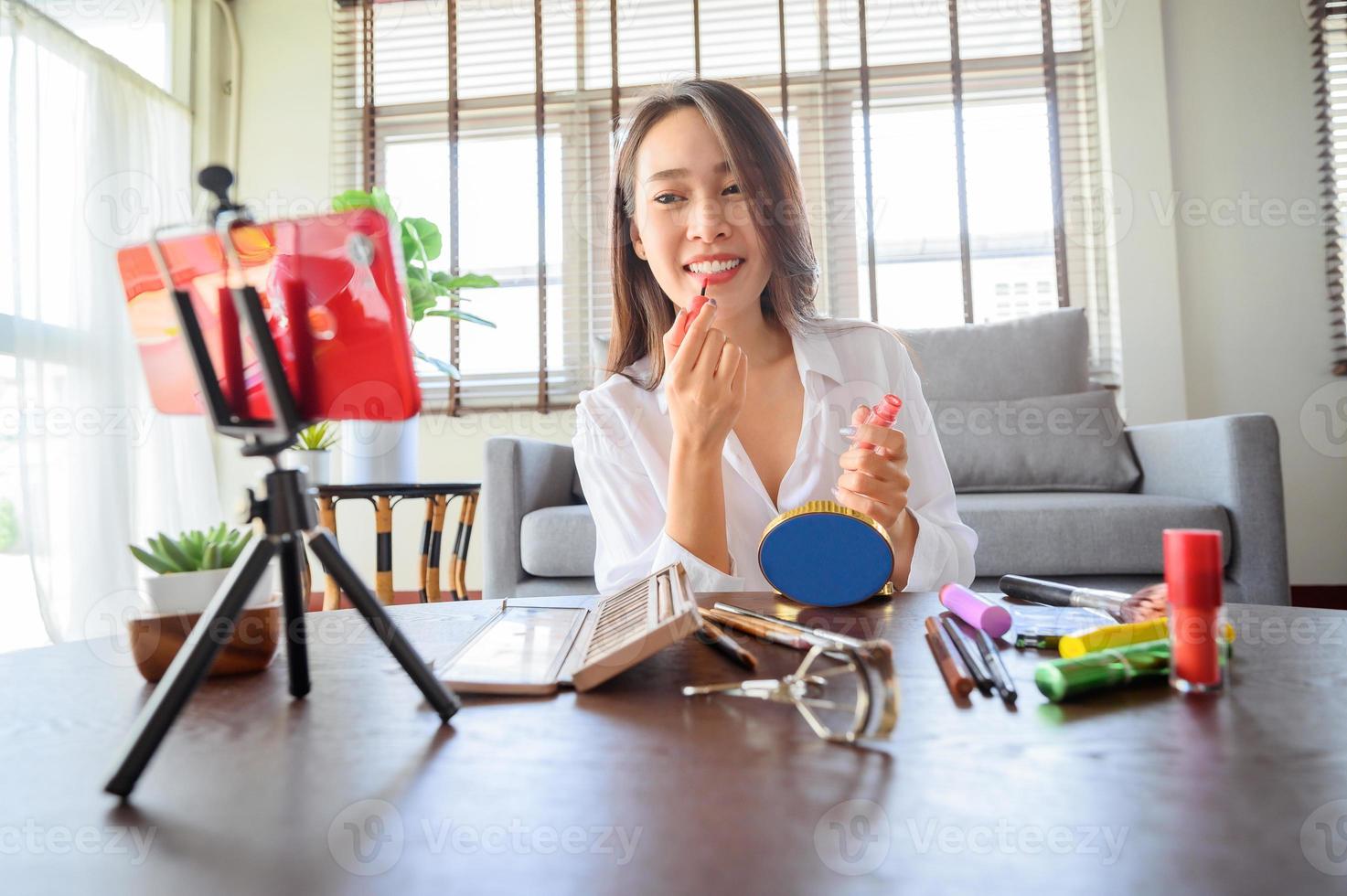 Mujer influyente blogger asiática con smartphone foto