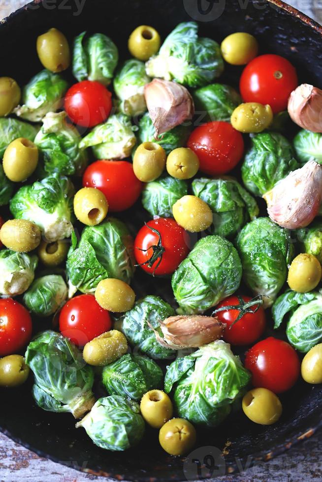 Brussel sprouts with vegetables and herbs in a pan photo