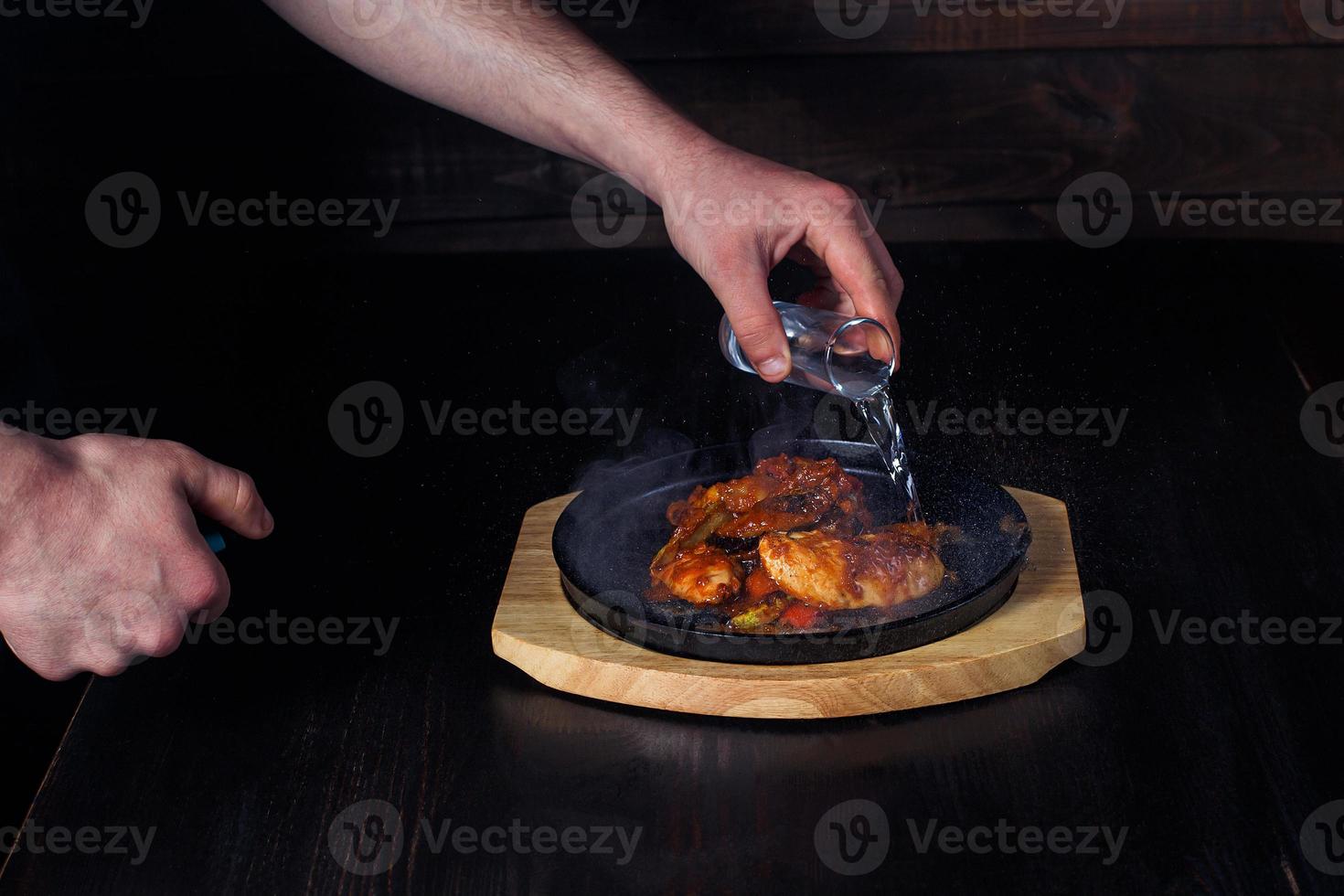 fajitos, meat in a frying pan with fire on a wooden tray, beautiful serving, dark background photo