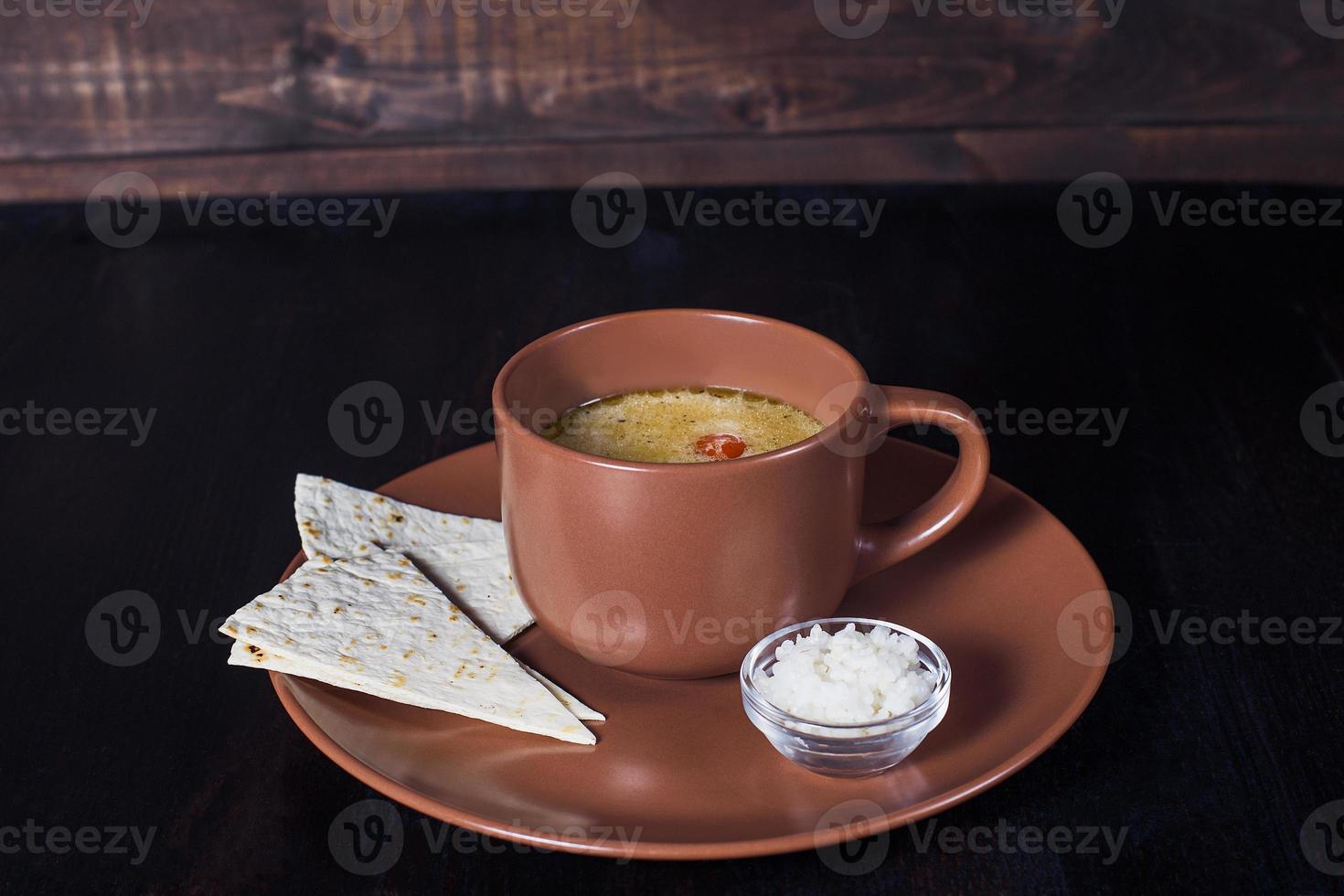 creamy soup with pita bread in a plate, beautiful serving, dark background photo